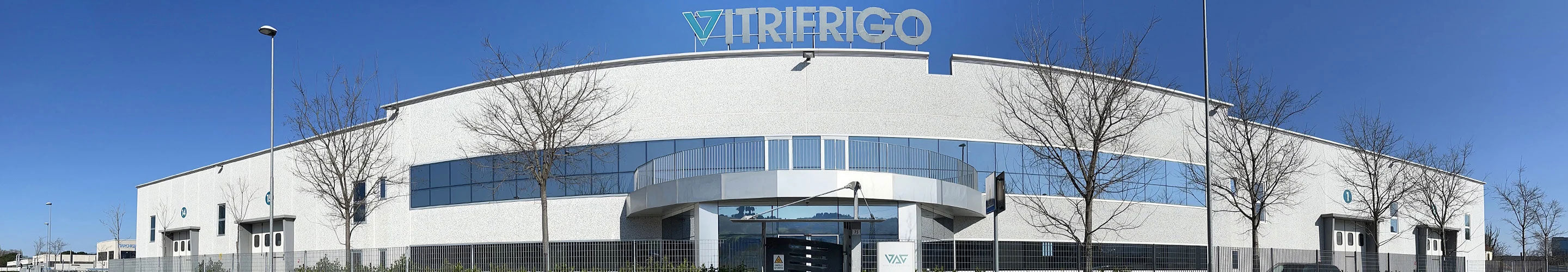 Vitrifrigo社の現代的な白い外観の本社・工場建物、青空を背景に企業ロゴが屋上に設置されている