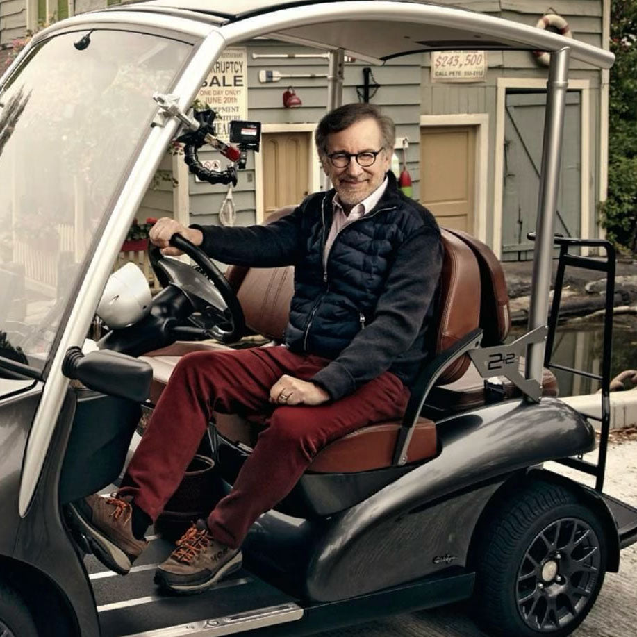撮影現場のようなロケーションで高級ゴルフカー「ガリア」の運転席に座るスティーブン・スピルバーグ氏 。